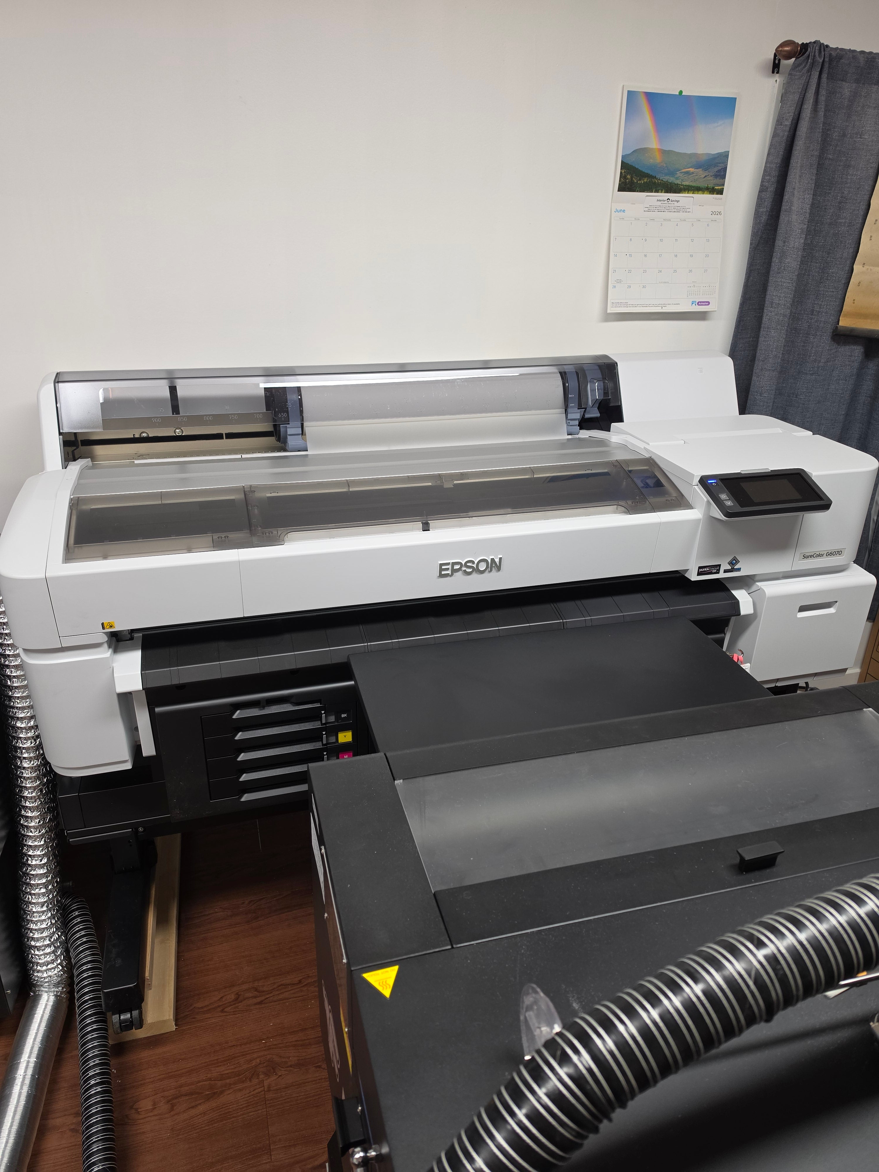 Epson DTF G6070 printer on a table with a white wall background